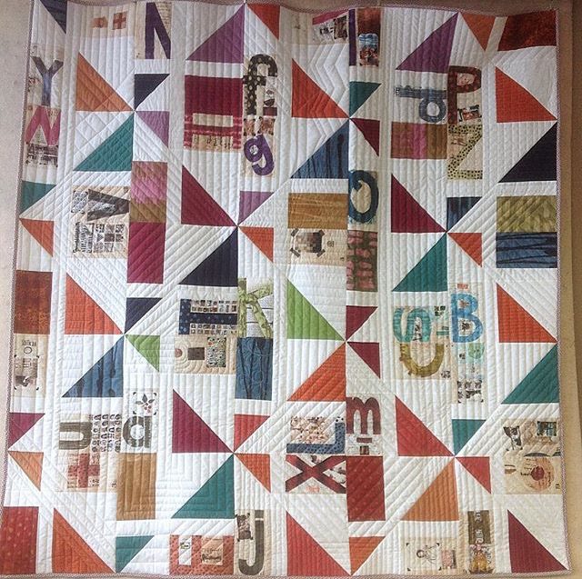 A beautiful lap quilt using an alphabet fabric panel and the Checker quilt block pattern at BlossomHeartQuilts.com