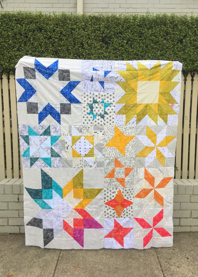 An Alison Glass rainbow quilt using the Aurora pattern from BlossomHeartQuilts.com