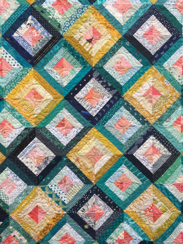 Scrap quilt from Treasure Hunt quilt block tutorial in navy, mustard, teal, coral by BlossomHeartQuilts.com