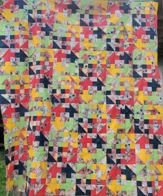 Bright and colourful churn dash quilt